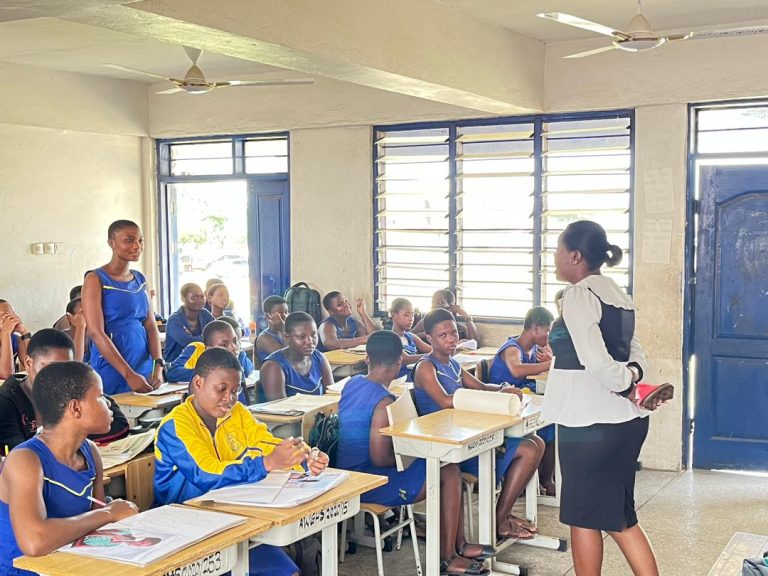 A classroom of engaged students in blue uniforms attentively participating in a Right to Information sensitization session at Accra Wesley Girls Senior High School.